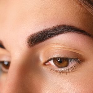 Young woman with beautiful eyebrows after correction, closeup